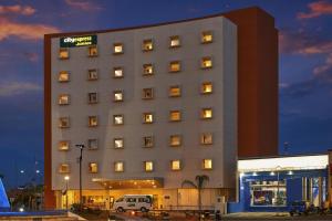 a hotel building with a sign on top of it at City Express Junior by Marriott Aguascalientes Centro in Aguascalientes