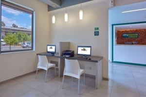 una oficina con un escritorio con dos ordenadores. en City Express Junior by Marriott Aguascalientes Centro en Aguascalientes