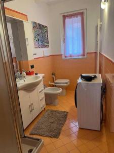 ein Badezimmer mit einem WC, einem Waschbecken und einem Spiegel in der Unterkunft Let It Be Franciacorta in Gussago