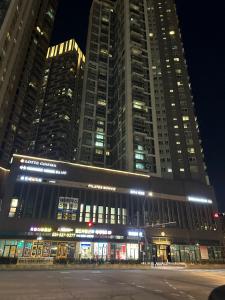een groot gebouw met veel ramen 's nachts bij Byeollae Station ipark Suite in Namyangju