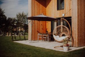 a patio with an umbrella and a table and chairs at Domki Ulkowo in Słajszewo