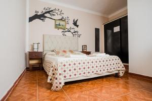 a bedroom with a bed with a tree on the wall at Hotel Alojamiento Raque-Lito in Patquía