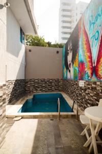 a swimming pool with a painting on the side of a building at Bahia 79 Apartasuites Cerca al Centro in Cartagena de Indias