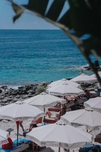 澤爾米烏的住宿－Empire Beach Resort ADULTS ONLY，海滩上的一组白色遮阳伞