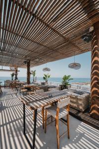 a patio with a table and chairs and the beach at Empire Beach Resort ADULTS ONLY in Dhërmi