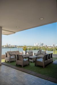 un patio con sillas y mesas y vistas al agua en Bahia 79 Apartasuites Cerca al Centro, en Cartagena de Indias