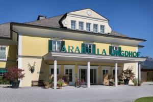um grande edifício amarelo com um sinal nele em Arabella Jagdhof Resort am Fuschlsee, a Tribute Portfolio Hotel em Hof bei Salzburg