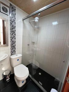 uma casa de banho com um WC e uma cabina de duche em vidro. em Apartamento en Normandia a 10 minutos del aeropuerto em Bogotá