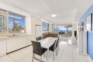 a kitchen and dining room with a table and chairs at Sands On Greenmount Unit 4 in Gold Coast