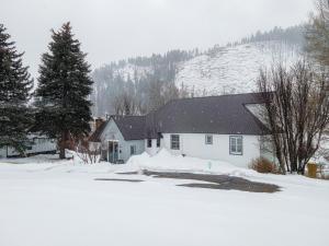 a white house with snow on the ground at Antlers on the Creek Bed & Breakfast in Durango