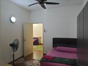 a room with a bed and a ceiling fan at Layyin's Damai Residences in Shah Alam