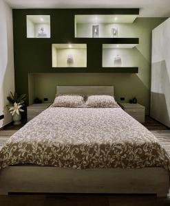 una camera da letto con un grande letto con pareti verdi di Il nido del Viaggiatore a San Giorgio Ionico