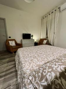 a bedroom with a bed and a dresser and a television at Il nido del Viaggiatore in San Giorgio Ionico