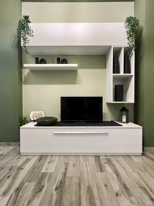 un soggiorno con pavimenti in legno e TV a schermo piatto di Il nido del Viaggiatore a San Giorgio Ionico