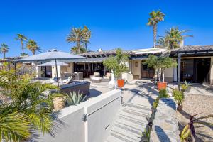 uma vista exterior de uma casa com palmeiras em Hermitage Paradise em Cabo San Lucas