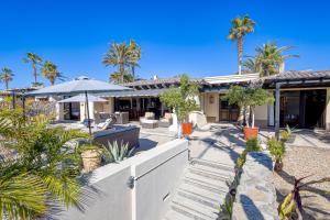 an exterior view of a house with palm trees at Hermitage Paradise in Cabo San Lucas
