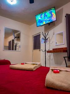 1 dormitorio con 2 camas y TV en la pared en Hotel Buenos Aires, en Durango