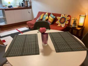 a table with a vase with a rose on top of it at Bella vista departamento amoblado in Iquique