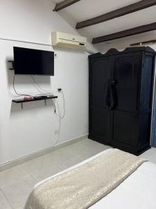 um quarto com um armário preto e uma televisão em Cabaña de descanso, Rodadero em Gaira