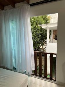 um quarto com uma varanda com uma cama e uma janela em Cabaña de descanso, Rodadero em Gaira