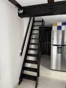 uma escada de madeira numa cozinha com um frigorífico em Cabaña de descanso, Rodadero em Gaira