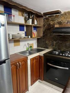 uma cozinha com um fogão e um lavatório em Cabaña de descanso, Rodadero em Gaira