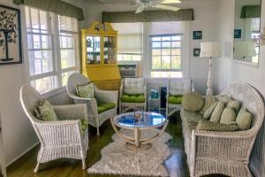 sala de estar con sillas de mimbre y mesa en Cherry Grove Enchantment, en Cherry Grove