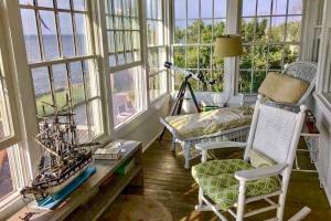a living room with windows and a table and chairs at Cherry Grove Enchantment in Cherry Grove