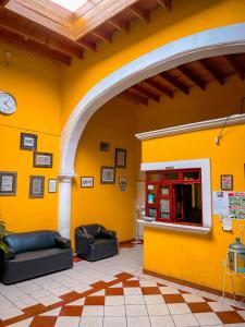a yellow wall with two couches in a room at Hotel Buenos Aires in Durango