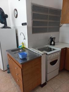 a kitchen with a stove and a sink at Apartamento Pelourinho Praça da sé in Salvador