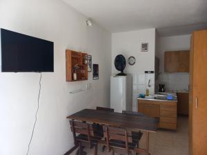 a kitchen with a table and a television on a wall at Apartamento Pelourinho Praça da sé in Salvador
