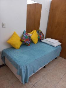 a bed with four pillows on top of it at Apartamento Pelourinho Praça da sé in Salvador