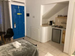 een kamer met een blauwe deur en een keuken bij Pension Irene 2 in Naxos Chora