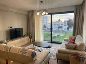 a living room with two couches and a large window at Bella Mare Residence Luxury Apartment in Famagusta