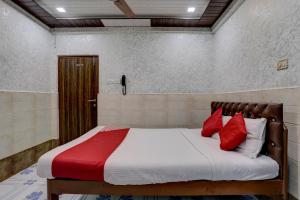 1 cama con almohadas rojas en una habitación en OYO Flagship Hotel Sapna Residency, en Bombay