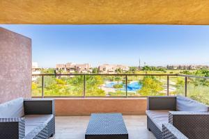 balkon z kanapami i widokiem na basen w obiekcie Luxurious Prestigia Golf Apt w Marakeszu
