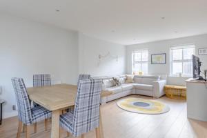 a living room with a table and a couch at Lovely 2BD House on Private Road Clapham Common! in London