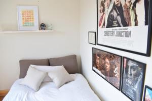 Contemporary 2BD Flat 4 Mins to Finsbury Park! في لندن: غرفة نوم مع سرير مع الأفلام على الحائط