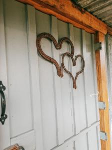 una puerta con dos corazones en la pared en Rocky Creek Shepherds Hut, en Fox Glacier