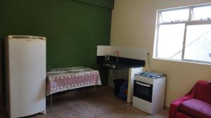 a kitchen with a sink and a table in a room at Hospedagem do Marcão in Belo Horizonte