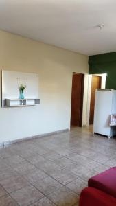 leeres Zimmer mit Kühlschrank und Fliesenboden in der Unterkunft Hospedagem do Marcão in Belo Horizonte