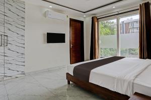 1 dormitorio con cama y ventana grande en Collection O Vikrant Residency, en Gurgaon
