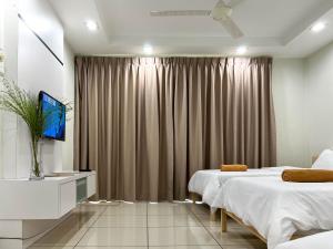 a hotel room with two beds and a television at Modern Muji Home Retreat near Taiping Lake Garden with Free Netflix in Taiping