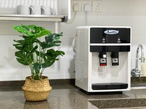 a coffee machine sitting on a counter next to a plant at Modern Muji Home Retreat near Taiping Lake Garden with Free Netflix in Taiping