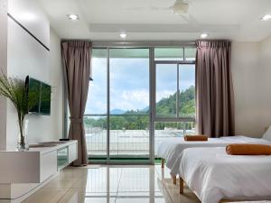 a bedroom with two beds and a large window at Modern Muji Home Retreat near Taiping Lake Garden with Free Netflix in Taiping