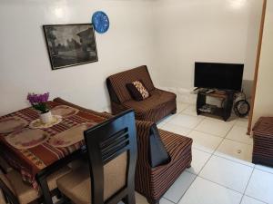 sala de estar con mesa, sillas y TV en Q'osqo Apartments, en Cusco