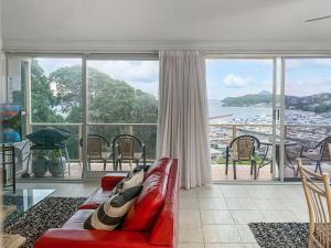 a living room with a red couch and a large window at Laman Lodge Unit 5 15 Laman Street in Nelson Bay