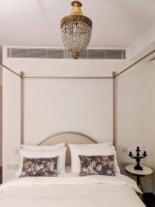 a bedroom with a bed with a chandelier above it at Soho West End in London