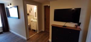 a living room with a flat screen tv on a wall at À mi-chemin in Marcillac-Vallon +4 photos