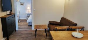 a living room with a couch and a table at À mi-chemin in Marcillac-Vallon